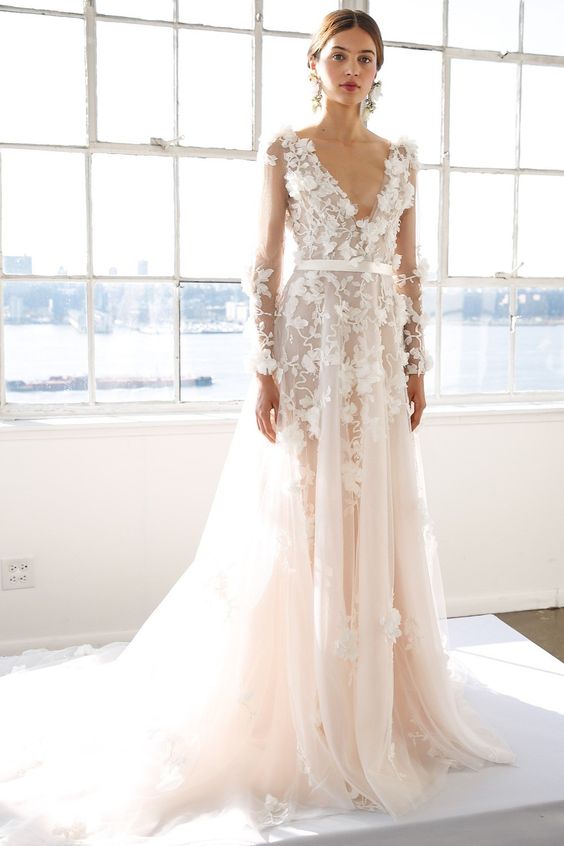Picture Of a blush wedding dress with a plunging neckline .
