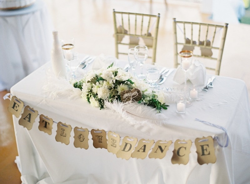 Picture Of a paper bunting, candles and a lush floral centerpiece .